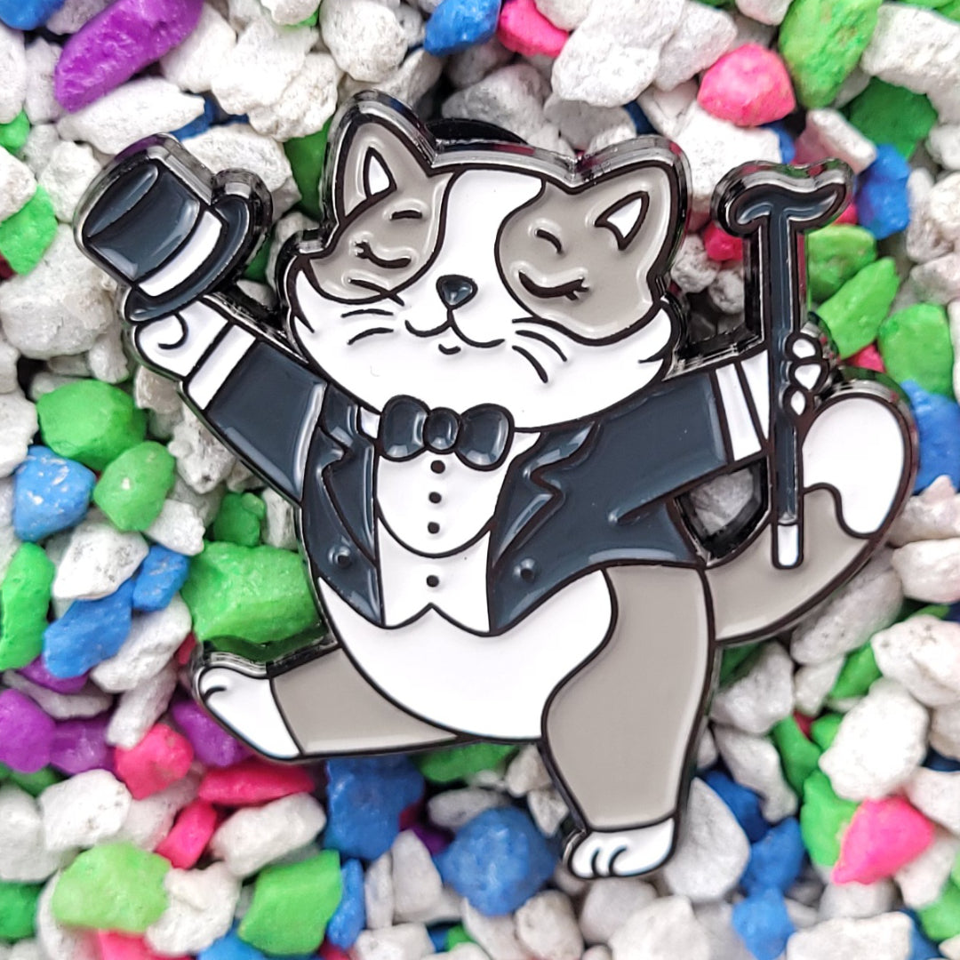 Rizz Kitty Enamel Pin. A cat Enamel Pin Wearing Tuxedo, holding hat and cane.