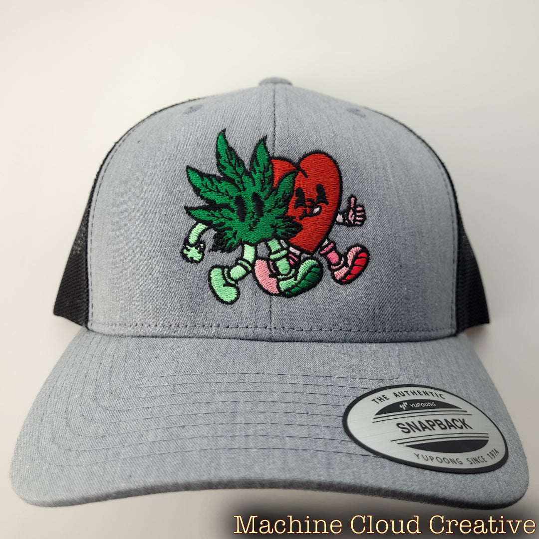 Front of hat with cartoon cannabis leaf and heart embroidered on it.