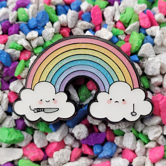 Enamel pin of two cartoon clouds connected by a rainbow. One is smiling and holding a knife toward the other, who is frowning.